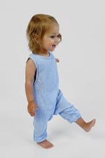 Child wearing a light blue sleeveless romper on a white background