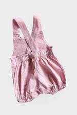 Back of light pink overalls on a light grey background