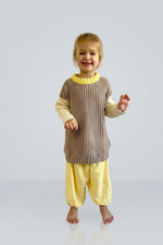 Child wearing a brown and yellow knit jumper on a light grey background