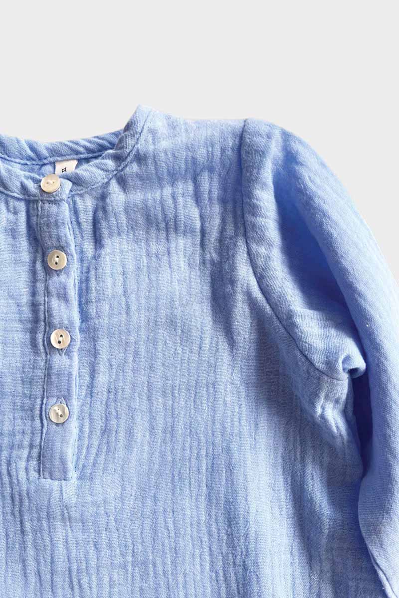 Long sleeve blue jumpsuit front buttons on grey background