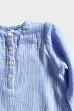 Long sleeve blue jumpsuit front buttons on grey background