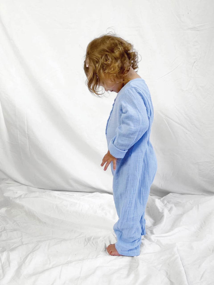 Blue baby jumpsuit with long sleeves modelled side view