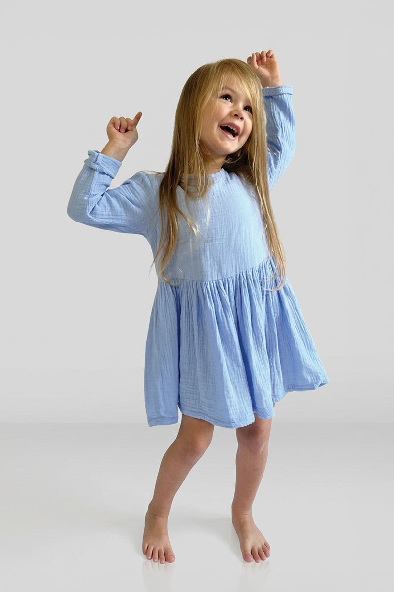 Child wearing a Long Sleeve blue dress on a white background