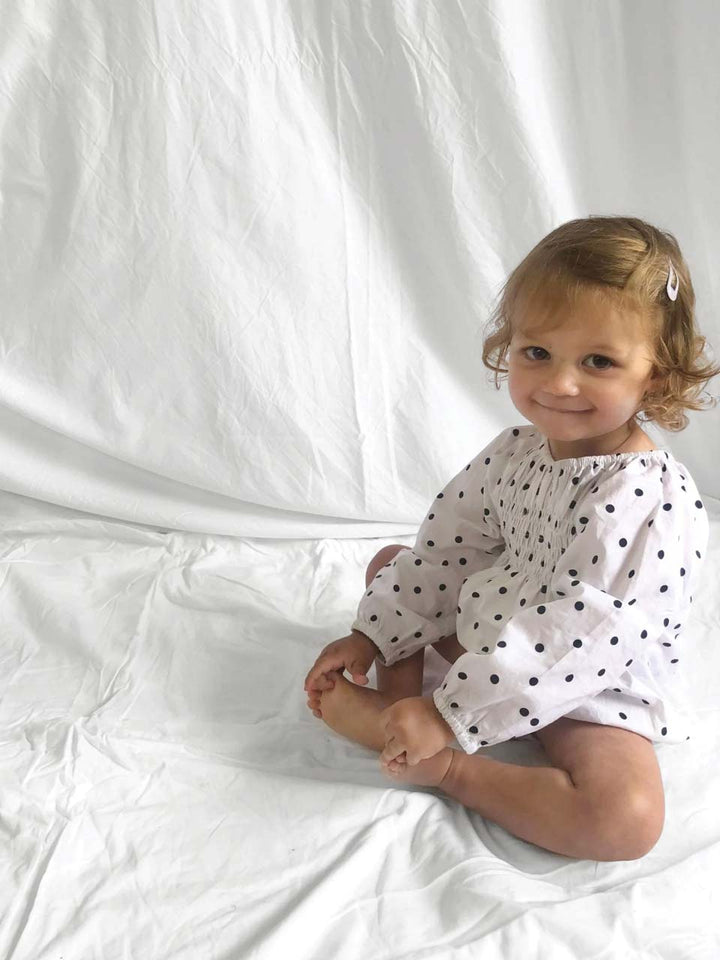 Romper smocked with long sleeves in polka dot modelled front view 2