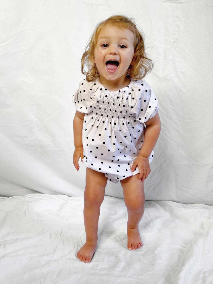 Romper smocked with short sleeves in polka dot modelled front view