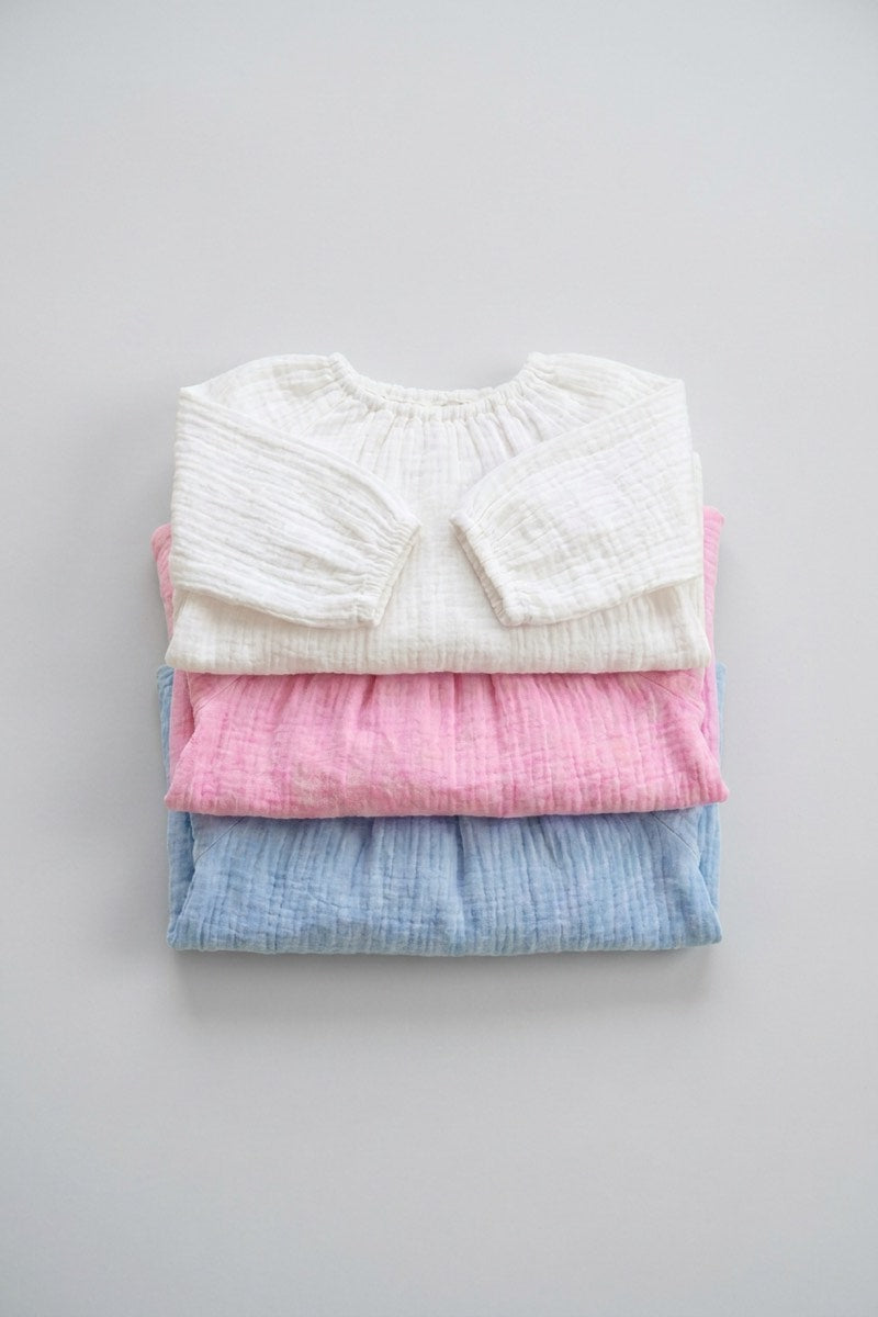 Three bundled rompers, folded flat lay, white pink and sky blue