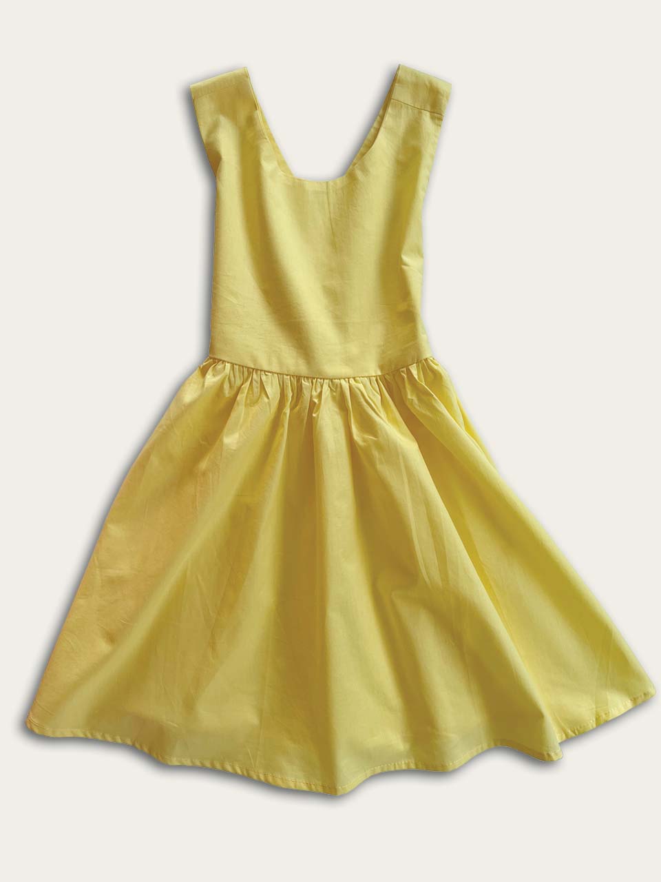 Yellow pinafore dress front on a white background