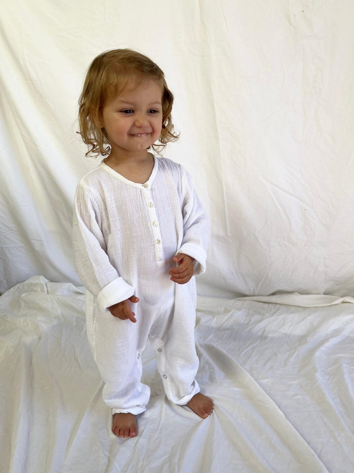 Baby jumpsuit with long sleeves in white modelled front view