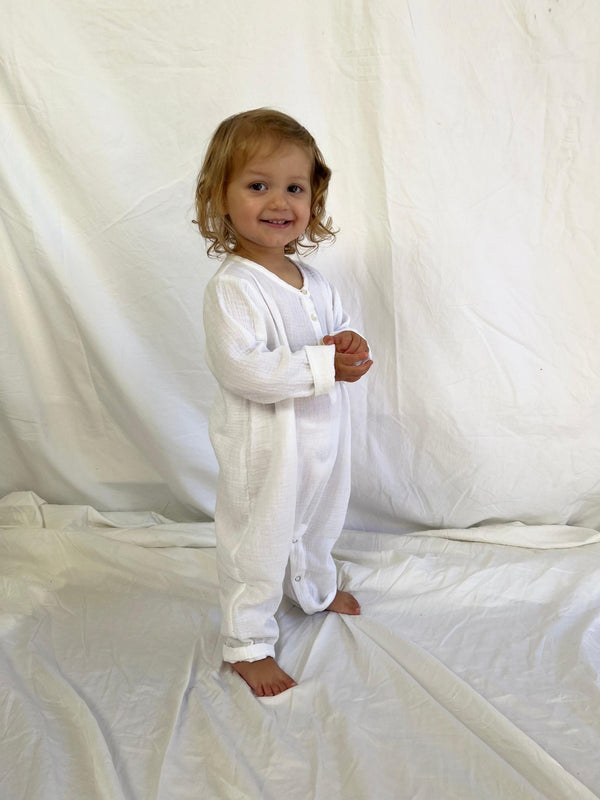 Baby jumpsuit with long sleeves in white modelled side view