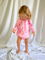 Young child wearing a Long Sleeve Romper in Paisley Red colour