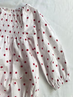 Romper smocked with long sleeves in red polka dot arm view