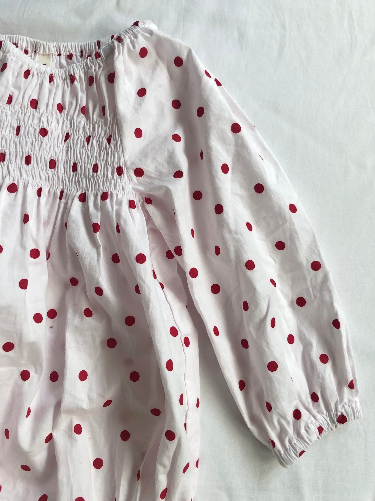 Romper smocked with long sleeves in red polka dot arm view