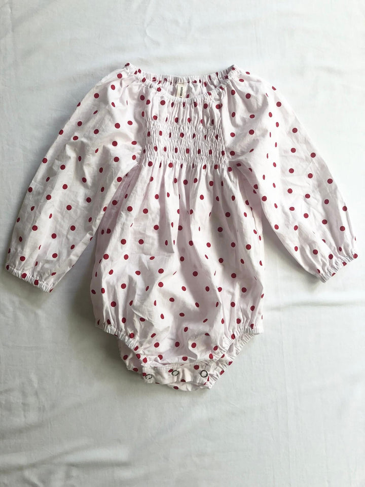 Romper smocked with long sleeves in red polka dot front view